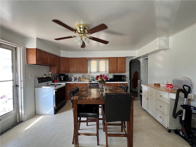 kitchen with light carpet, white electric range, a healthy amount of sunlight, and ceiling fan