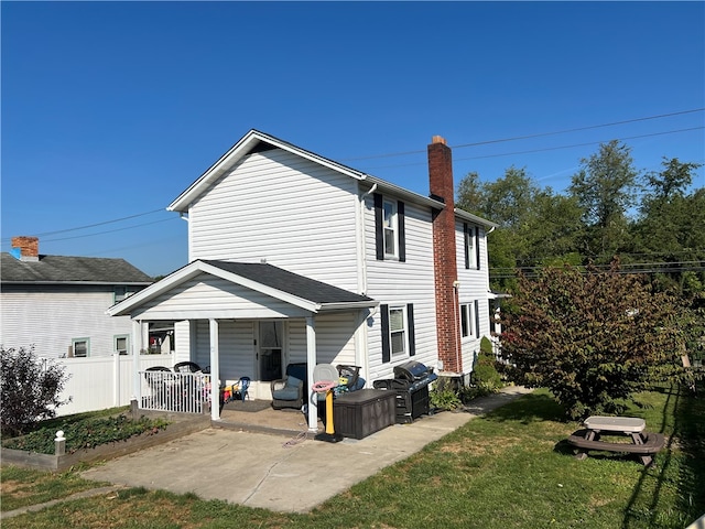 back of property featuring a lawn