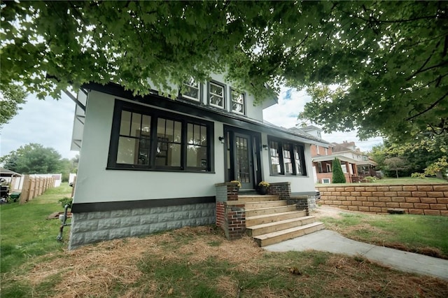 view of front facade with a front lawn and stucco siding