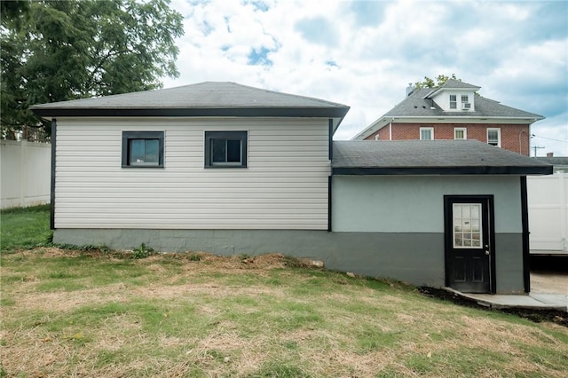 rear view of property with a lawn and fence