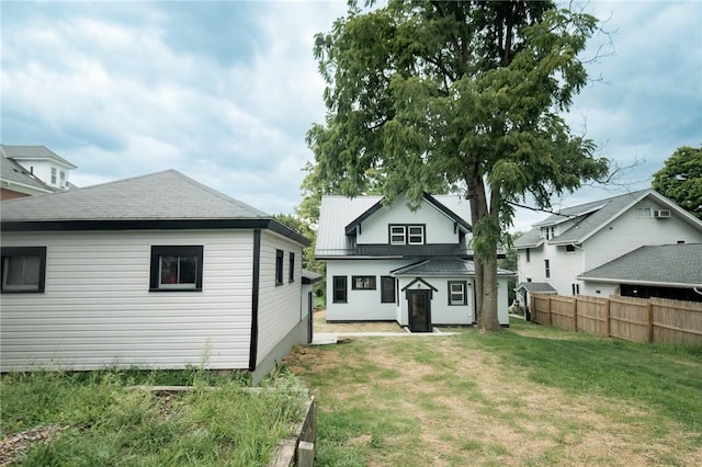 rear view of house with a yard and fence