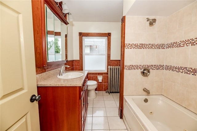 full bath featuring radiator, a combined bath / shower with jetted tub, tile patterned flooring, vanity, and tile walls