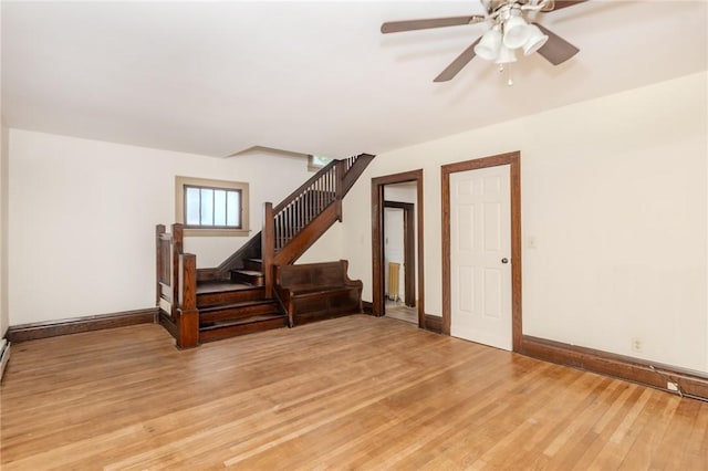 interior space featuring stairs, baseboards, light wood-style flooring, and radiator