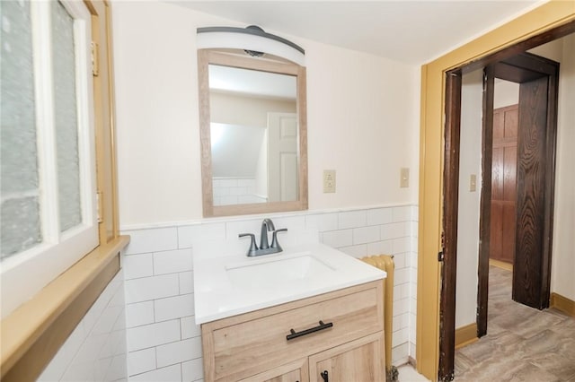 bathroom with a wainscoted wall, tile walls, and vanity