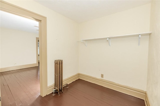 laundry area with radiator heating unit, baseboards, and dark wood finished floors