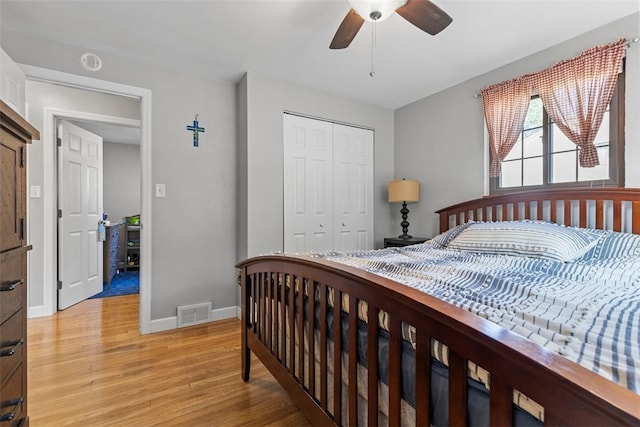 bedroom with light hardwood / wood-style flooring, ceiling fan, and a closet