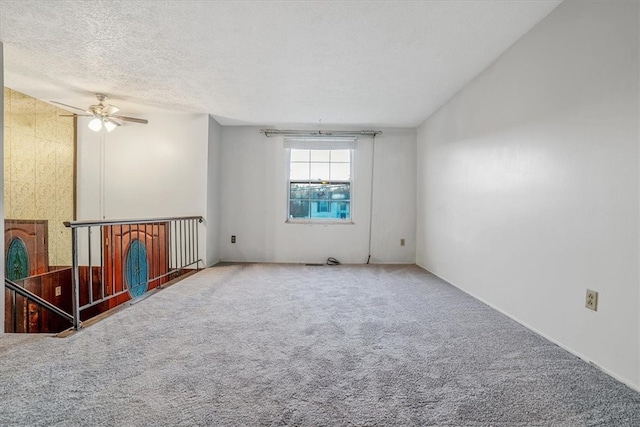 carpeted empty room with a textured ceiling and ceiling fan