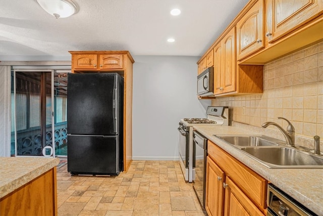 kitchen with appliances with stainless steel finishes, sink, and decorative backsplash