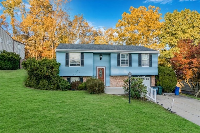 raised ranch featuring a front lawn and a garage