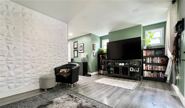 living room featuring tile walls, hardwood / wood-style flooring, and a healthy amount of sunlight