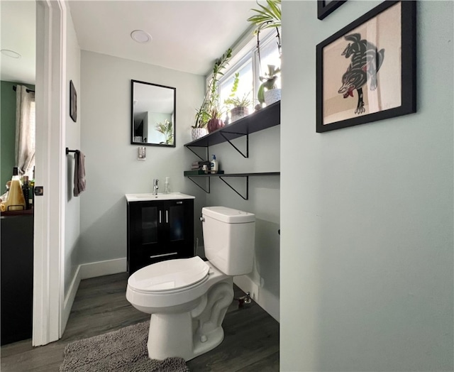 bathroom with hardwood / wood-style floors, vanity, and toilet