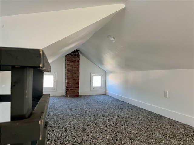 bonus room featuring dark carpet and lofted ceiling