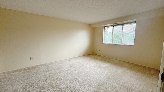 carpeted empty room featuring a textured ceiling