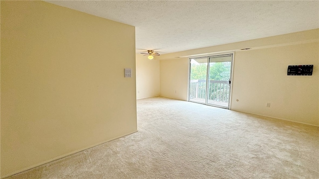 spare room with light colored carpet, a textured ceiling, and ceiling fan