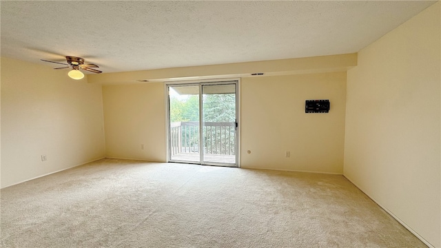 spare room featuring ceiling fan, a textured ceiling, and light carpet