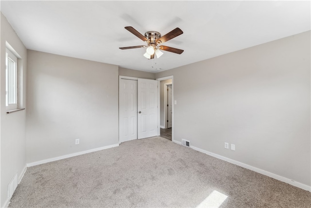 unfurnished bedroom featuring ceiling fan, a closet, and carpet