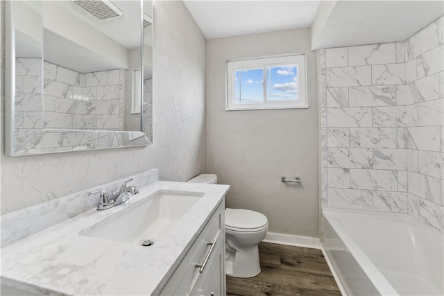 full bathroom featuring hardwood / wood-style flooring, tiled shower / bath, toilet, and vanity