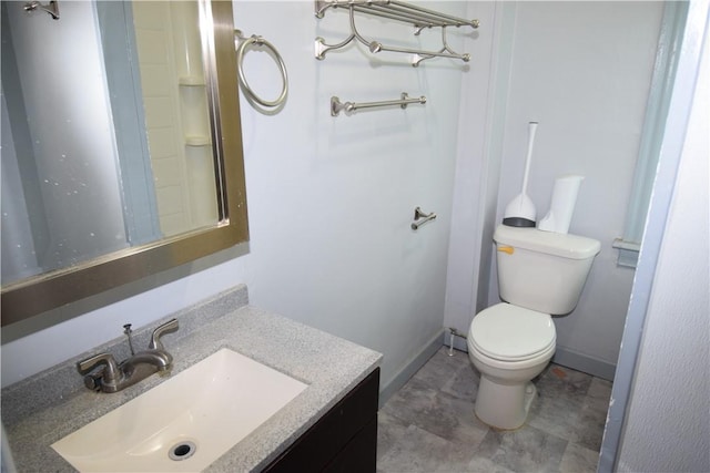 bathroom featuring baseboards, vanity, and toilet