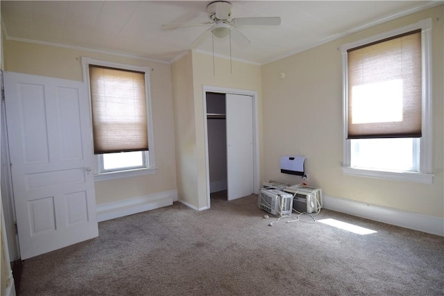 unfurnished bedroom with carpet, a closet, multiple windows, and crown molding