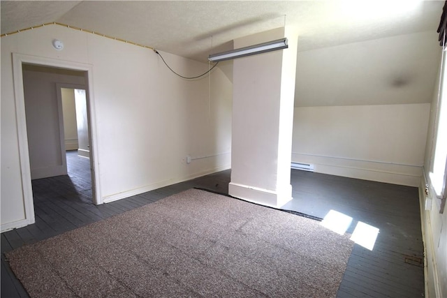 interior space with dark wood-style floors, baseboards, and a baseboard heating unit