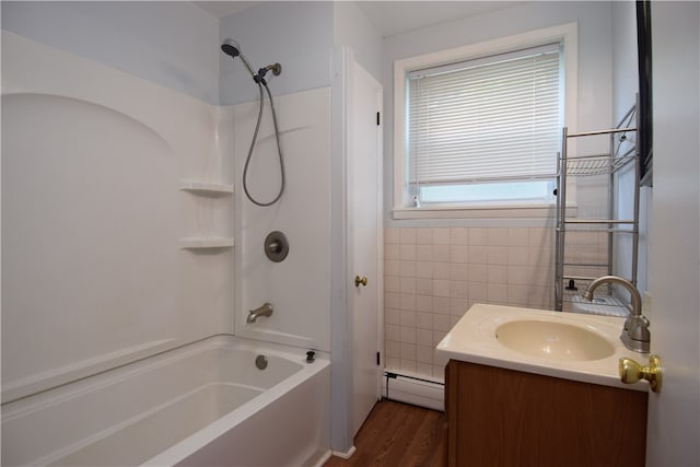 bathroom featuring a baseboard heating unit, vanity, shower / washtub combination, tile walls, and hardwood / wood-style flooring