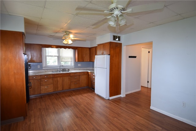 kitchen with ceiling fan, a drop ceiling, white fridge, and dark hardwood / wood-style flooring