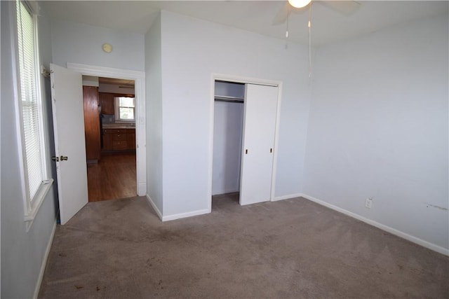 unfurnished bedroom with ceiling fan, carpet floors, a closet, and baseboards