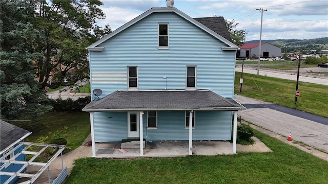 rear view of house featuring a patio area and a yard