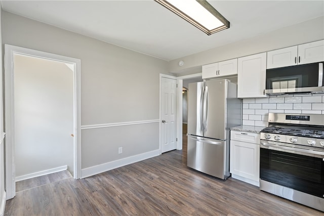 kitchen with appliances with stainless steel finishes, white cabinets, and dark hardwood / wood-style floors