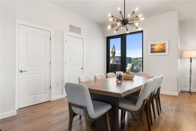 dining area featuring baseboards, an inviting chandelier, visible vents, and light wood-style floors