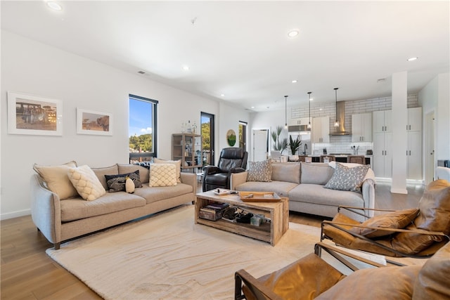 living room featuring recessed lighting, light wood-style flooring, and baseboards