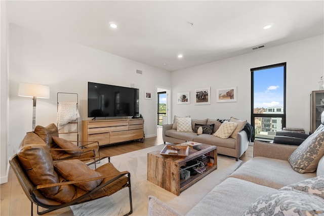 living area with a wealth of natural light, visible vents, light wood finished floors, and recessed lighting