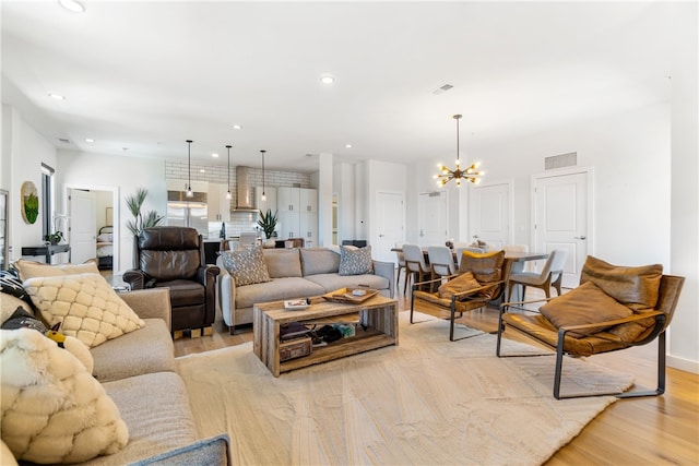 living room with recessed lighting, light wood-type flooring, visible vents, and a notable chandelier