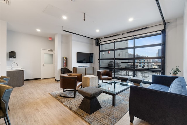 living room featuring recessed lighting, baseboards, visible vents, and light wood finished floors