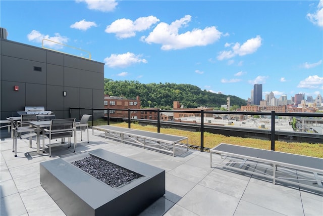 view of patio / terrace featuring a view of city and a fire pit