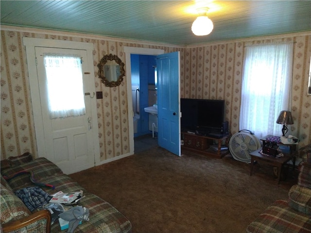 living room with wallpapered walls, plenty of natural light, ornamental molding, and carpet flooring