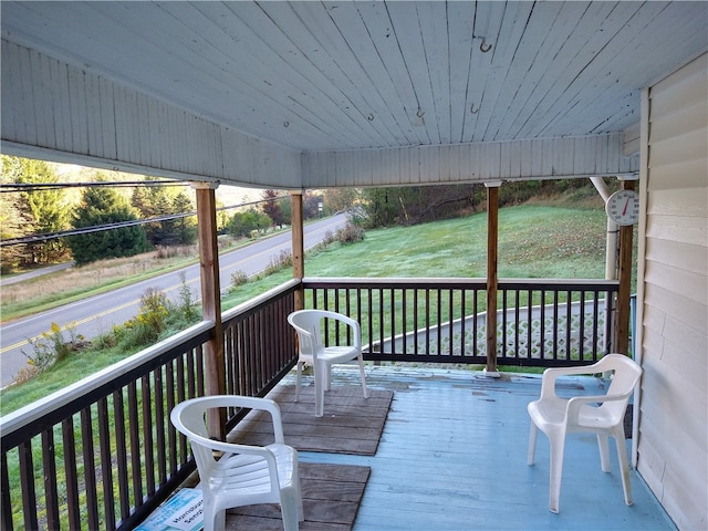 wooden deck featuring a lawn