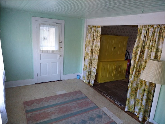 entryway featuring wallpapered walls and baseboards