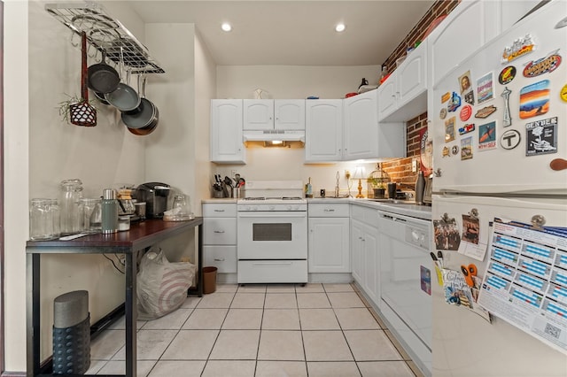 kitchen with white cabinets, light tile patterned floors, white appliances, and tasteful backsplash