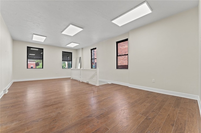 empty room featuring a textured ceiling and hardwood / wood-style floors