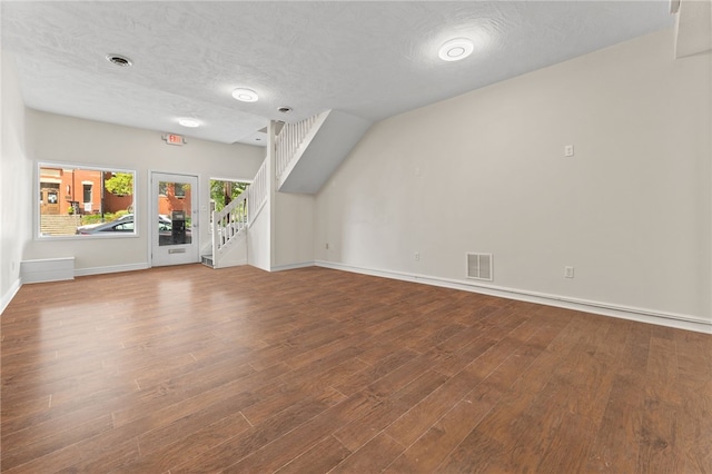 unfurnished living room with a textured ceiling and hardwood / wood-style floors