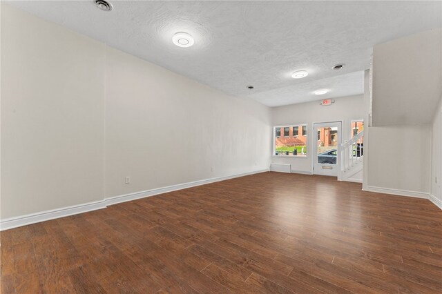 interior space with a textured ceiling and dark wood-type flooring