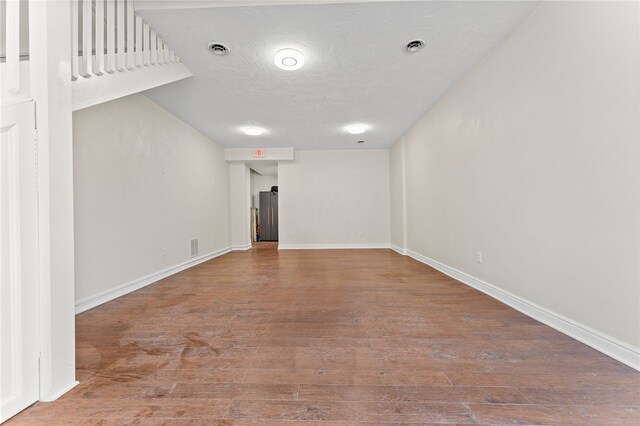 spare room featuring wood-type flooring and a textured ceiling