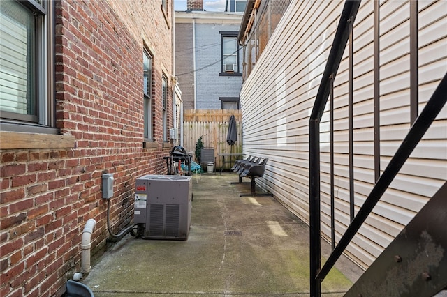 view of property exterior with a patio, central air condition unit, and cooling unit