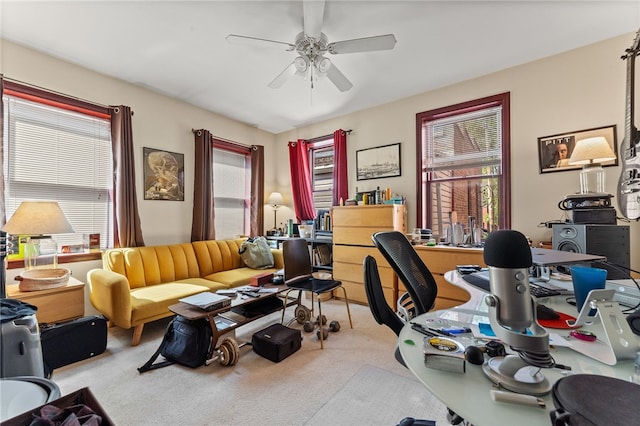 carpeted office space with ceiling fan