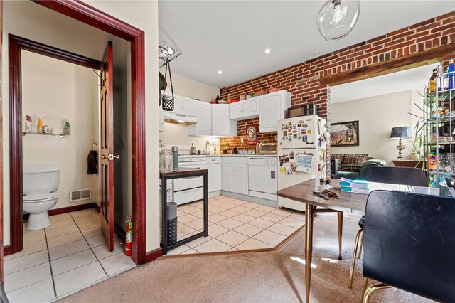 kitchen featuring brick wall, white cabinets, light tile patterned floors, and white appliances