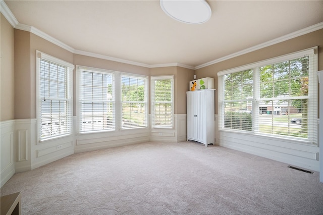 interior space with crown molding, light colored carpet, and a wealth of natural light