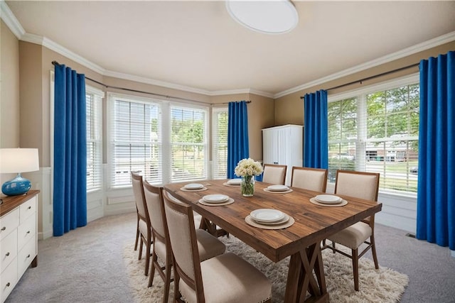 carpeted dining room featuring ornamental molding and a wealth of natural light