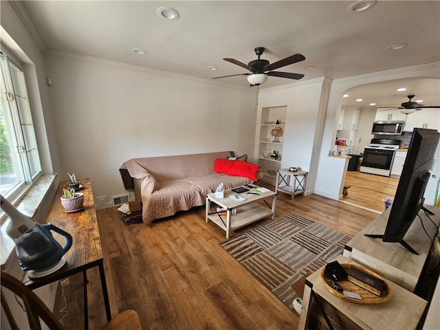 living room featuring ceiling fan, crown molding, and wood-type flooring