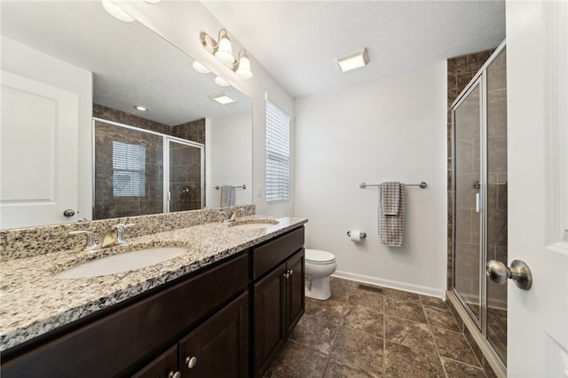 bathroom featuring a wealth of natural light, tile patterned flooring, vanity, toilet, and a shower with door